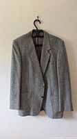 Front view of gray tweed blazer on hanger