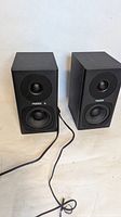 Front view of both black Fostex desktop monitor speakers showing drivers, LED and wire