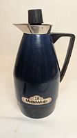 Front view of dark blue Matti & Maija carafe showing brand badge, handle and stopper