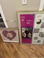 Both framed pieces leaning against wall