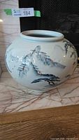 Overall view of globular porcelain moon jar with painted mountain scene