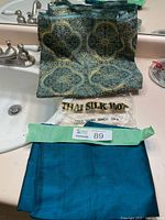 Teal silk piece, gold-blue brocade, Thai Silk packaging visible