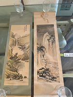 Both Chinese scroll paintings laid side by side showing full artwork