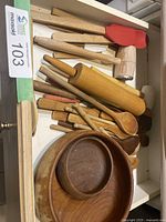 Drawer view of mixed wooden utensils, bowls, rolling pin and mallets