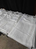 White grommet curtain panels laid out