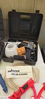 Wagner power painter in open case with accessories, paperwork and coiled wire visible