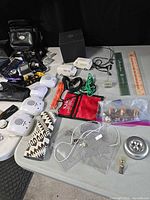 Overview of assorted electronics including camera bag, LED strips, rulers, model vans, cords and small parts