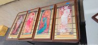 Four framed Art Nouveau style prints on table