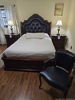 Full view of bed, headboard, nightstands and chair