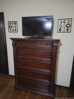 Dresser with TV on top and both wall art pieces mounted on wall