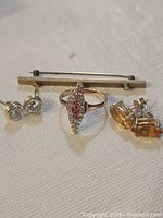 All four jewelry items side by side on fabric