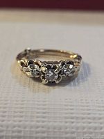 Front view showing three diamonds and floral motif setting