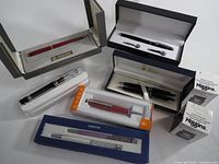 Overall view of six boxed pen sets and three Higgins ink boxes