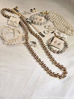 Overall view of necklaces, bracelets and earrings in lot