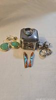 Group shot showing all items: ring, earrings, inlay dangles, Birks box