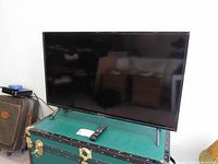 Front view of Samsung 43-inch TV on stand with remote