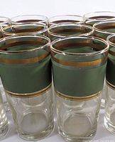 Front view of several tumblers showing olive band and gold trim