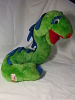 Full view of Cecil plush lying on side showing overall condition and tag