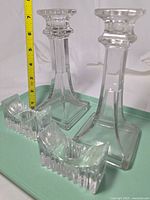 Pair of tall square-column candlesticks alongside pair of low ribbed block candlesticks with ruler for scale