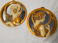 Both round Art Deco plaques front view