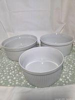 Three nesting white ribbed casserole dishes displayed together