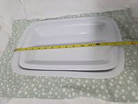 Top view showing both Dansk white platters with tape measure indicating approx length of larger piece