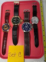 Front view of four Invicta watches on tray showing dial designs and straps