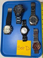 Front view of five Invicta wristwatches on blue tray