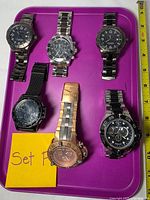 Front view of six Invicta watches on purple tray