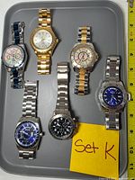 Front view of six Invicta watches on tray