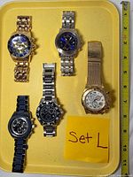 Front view of five Invicta wristwatches on tray, showing dial designs and finishes