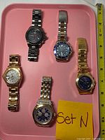 Top view of five Invicta watches on tray
