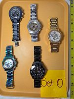 Front view showing all five Invicta watches arranged on tray