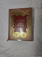 Front cover showing ornate gilt design and plastic dust jacket
