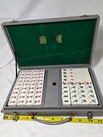 Open case showing tile trays and measuring tape for scale