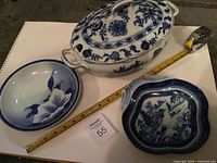 Three blue and white ceramic pieces with measuring tape