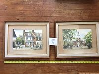 Both framed watercolor paintings side by side with measuring tape visible