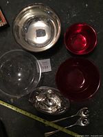 Group view of silver bowls, red and clear inserts, gravy boat, salad servers
