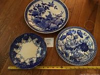 Three plates laid out with measuring tape for scale