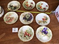 All eight Limoges plates with tape measure for scale