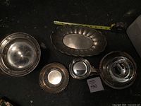 Five metal dishes laid out with tape measure reference