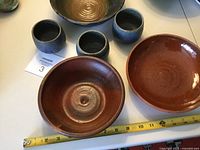 Group shot of three bowls and three tumblers with measuring tape for scale