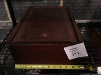 Top view of closed wooden box with measuring tape for scale