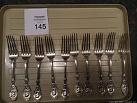 Full set of 10 matching sterling dinner forks displayed on tray.