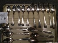 Tray with 11 teaspoons and 6 soup spoons showing patterns and overall condition