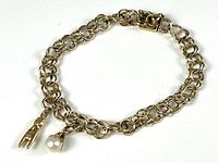 Full view of gold bracelet with both charms attached