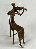 Full view of seated violin player sculpture