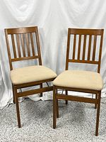 Front view of both Stakmore folding chairs showing wood frames and padded seats