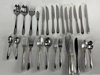 Full set laid out showing knives, forks, spoons, serving pieces with many still in plastic