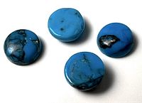 Four turquoise cabochons on white background